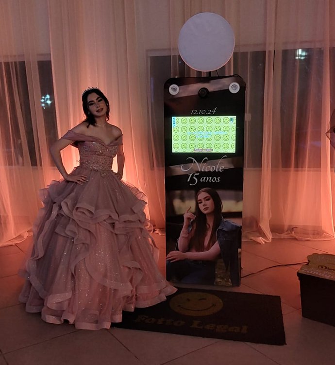 Aniversariante de 15 anos ao lado do totem personalizado